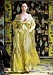 En modell i en gulskimrande klänning av Maxjenny Forslund.