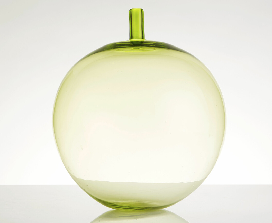 Poetiska <span class=" italic" data-lab-italic_desktop="italic">Äpplet</span>. Den underbara vasen i underfångsglas ritades för Orrefors 1955 men den lanserades först 1957. Höjd 36cm. Klubbades för 32000 kronor på Stockholms Auktionsverk. Äppleformad vas i ljusgrönt glas.