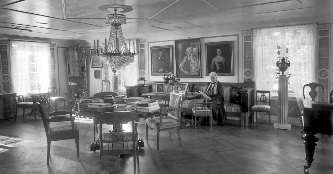 Selma Lagerlöfs sitter i en soffa hemma på Mårbacka