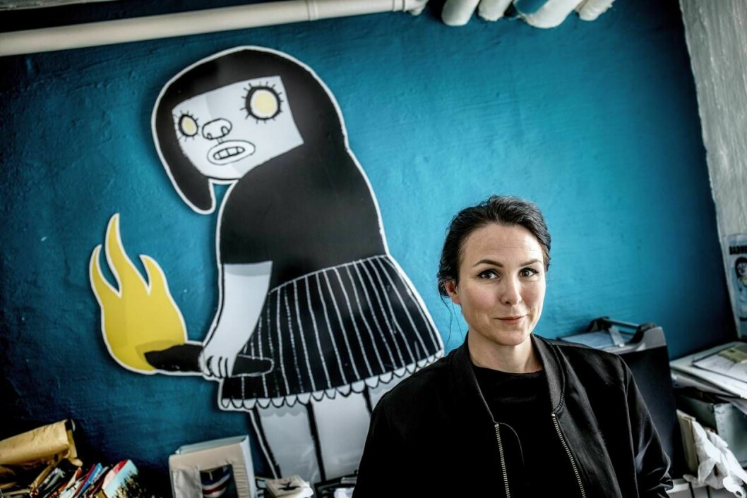 Nina Hemmingsson. Porträtt av Nina Hemmingsson med seriefigur i bakgrunden