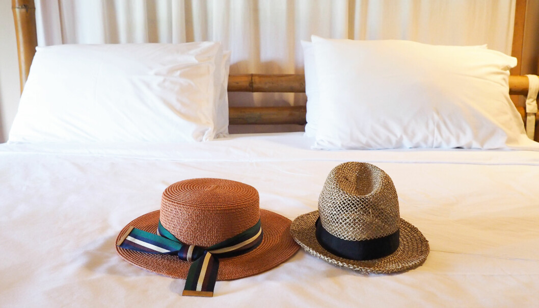 Två hattar som ligger på en säng.