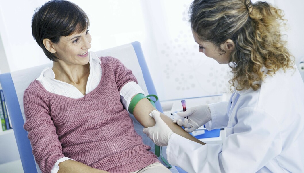 Sjuksköterska tar blodprov på kvinnlig patient.