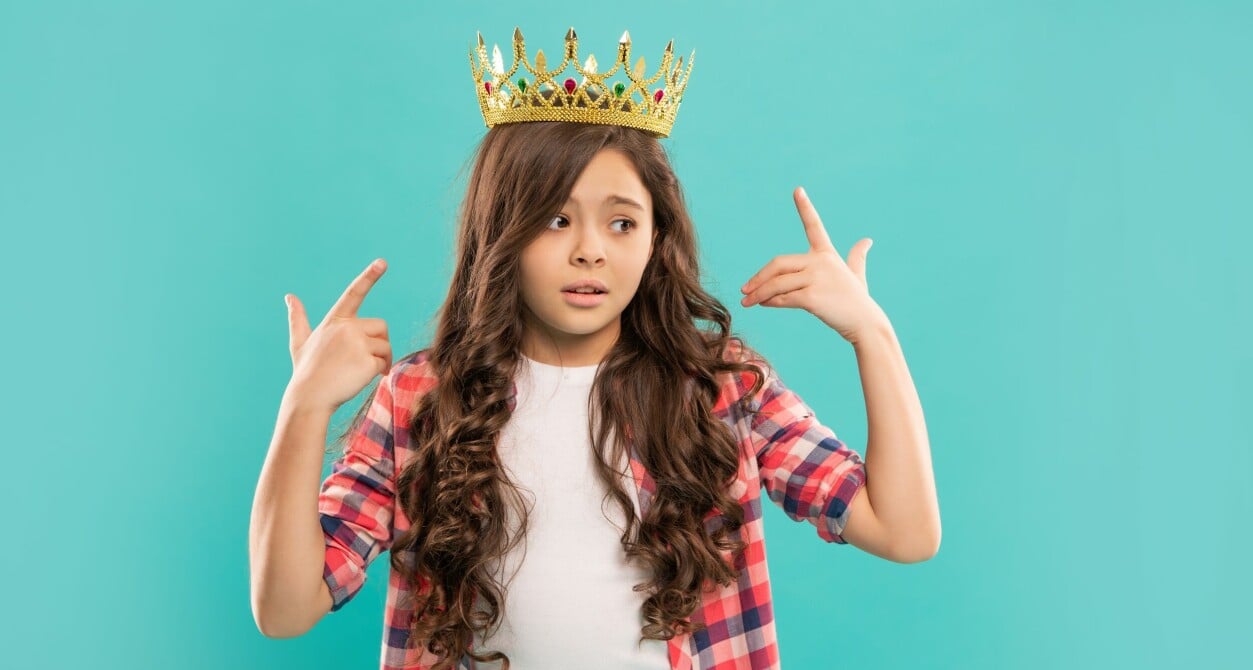 Una bambina con una corona reale in testa.