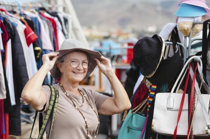 Kvinna som provar hatt i en second hand-butik.