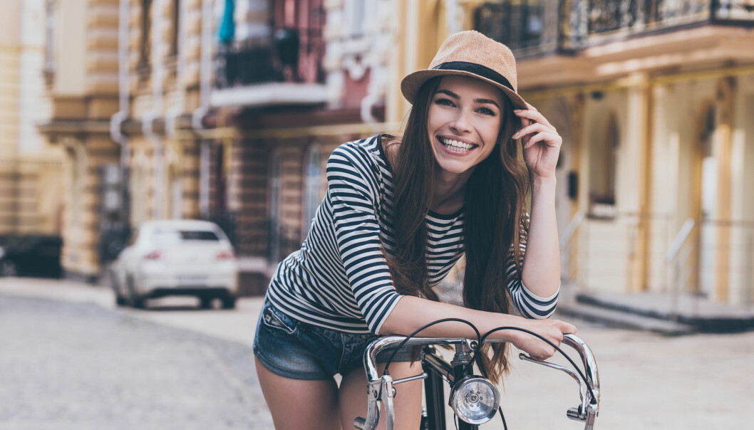 Hipstertjej med hatt och cykel