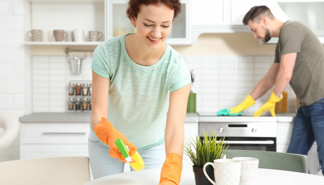 En man och kvinna städar ett kök med gummihandskar på
