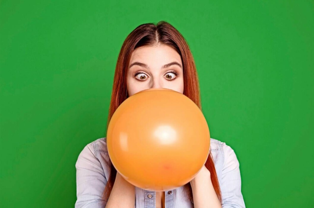 Kan du använda hjärnan smartare, tänka i nya banor, bedöma situationer bättre, vidga perspektiven och låta tankarna spira? Foto: TT En ung kvinna blåser upp en ballong och har ögonen i kors.