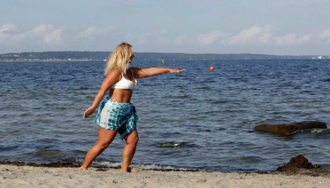 Kvinna tränar på stranden.