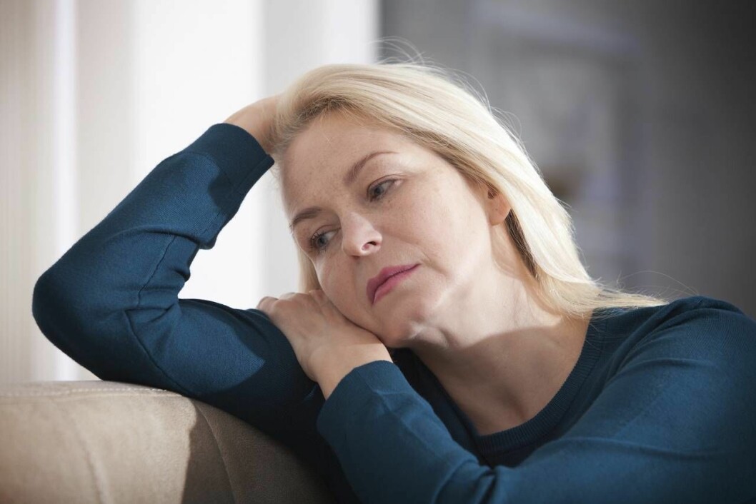 Problem med sköldkörteln är en av våra vanligaste folksjukdomar, som främst drabbar kvinnor. En kombination av läkemedel kan behövas för att må riktigt bra. Kvinna ser ledsen ut i en soffa