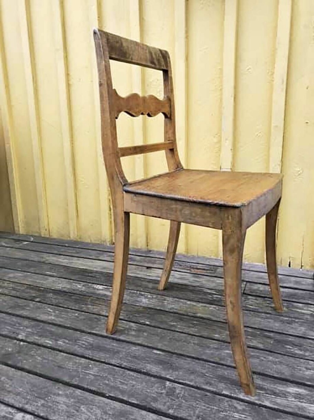 En läsare vill veta hon vårdar sina sköra stolar. Foto: Privat Trästol av äldre modell framför gul träfasad