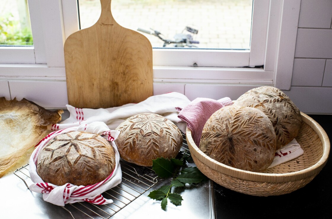 Snittade och bakade surdegsbröd ligger vackert upplagda i ett kök.