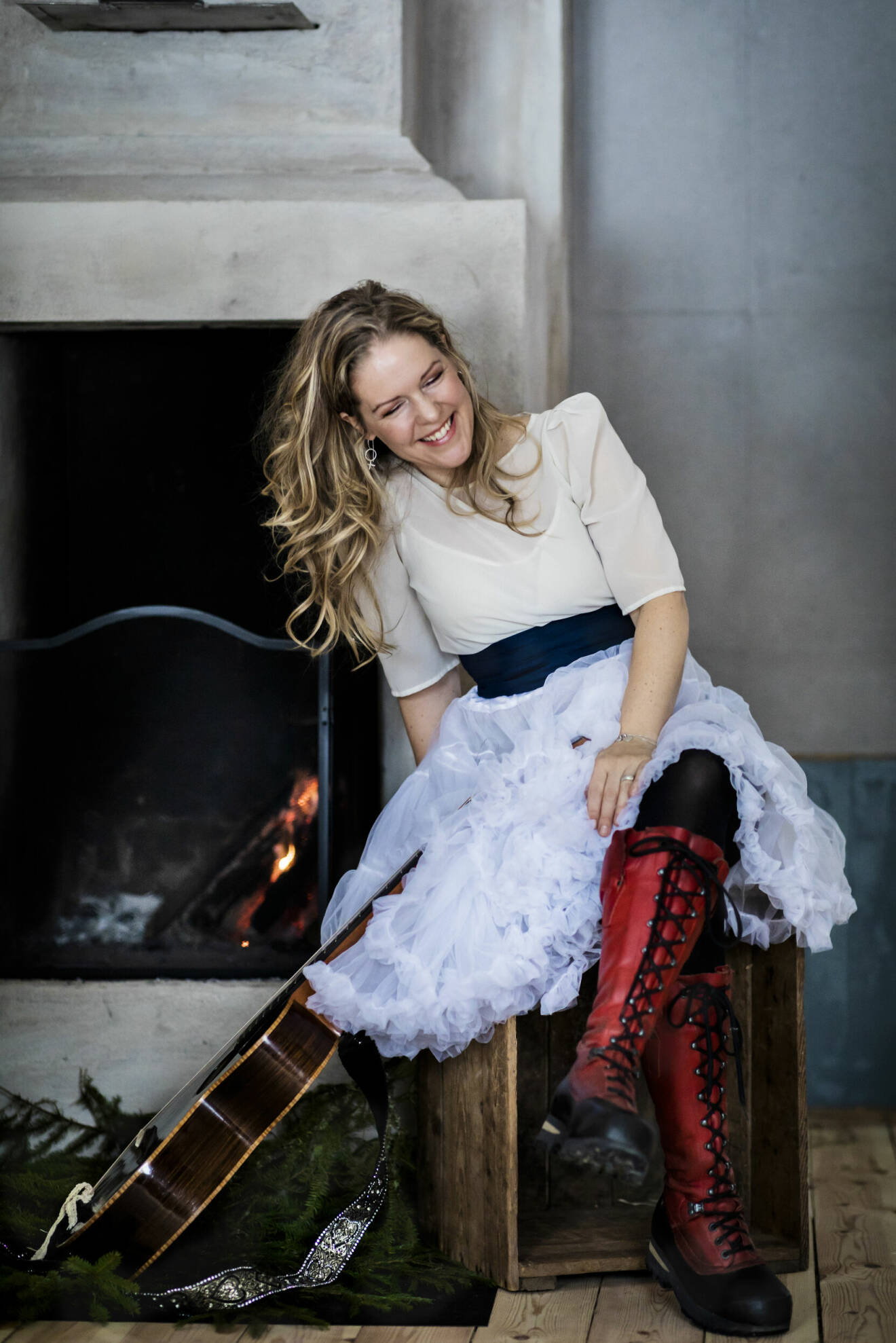 Artisten Sofia Karlsson i vit tyllkjol, skrattar.
