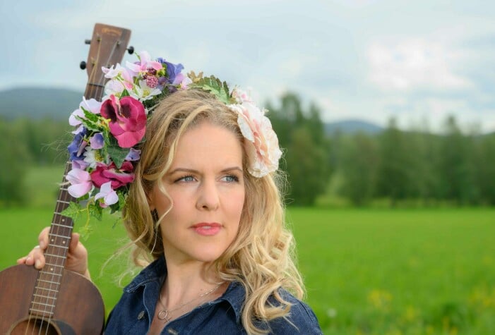 – I jobbiga tider med sjukdomar och krig hoppas jag kunna förmedla styrka, hopp och glädje med min musik, säger Sofia Karlsson. Närbild på artisten Sofia Karlsson med blommor i håret.