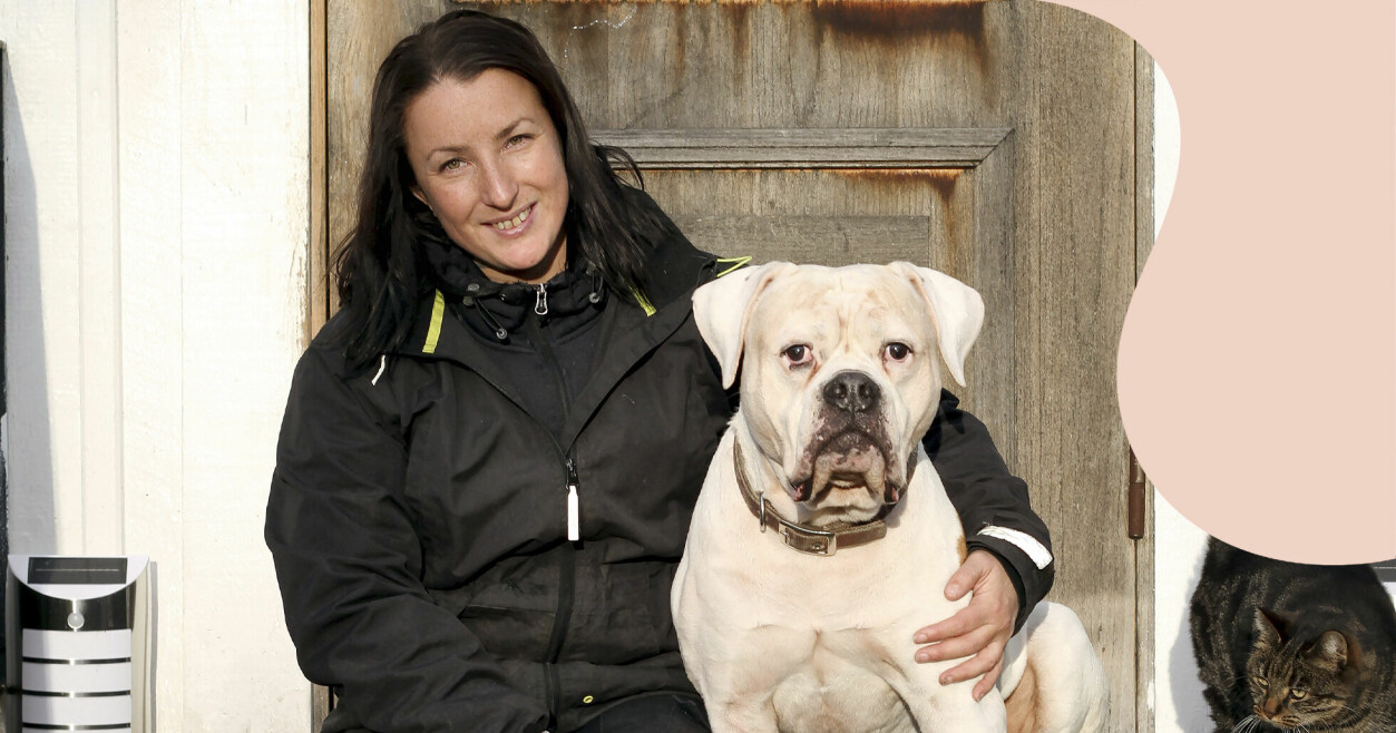 Sofia sitter på en trappa med sin vita hund Kaos. Kaos är en amerikansk bulldog.