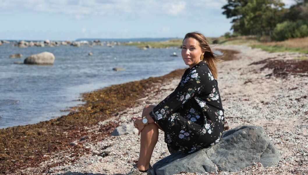 Sofie tvingades ibland se hur hennes pappa misshandlade mamman. Sofie sitter på en sten på stranden.