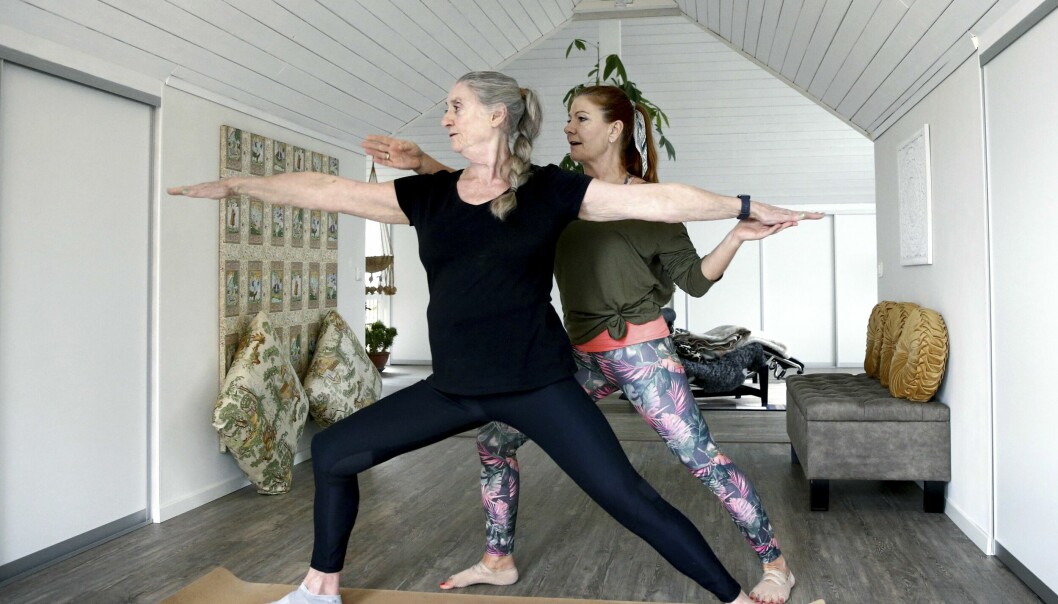 Tillsammans med yogaläraren Susanne Lovensjö håller Solveig på att ta fram ett pass som passar äldre. Yogaläraren Susanne Lovensjo står bakom Solveig och instruerar henne i yoga.