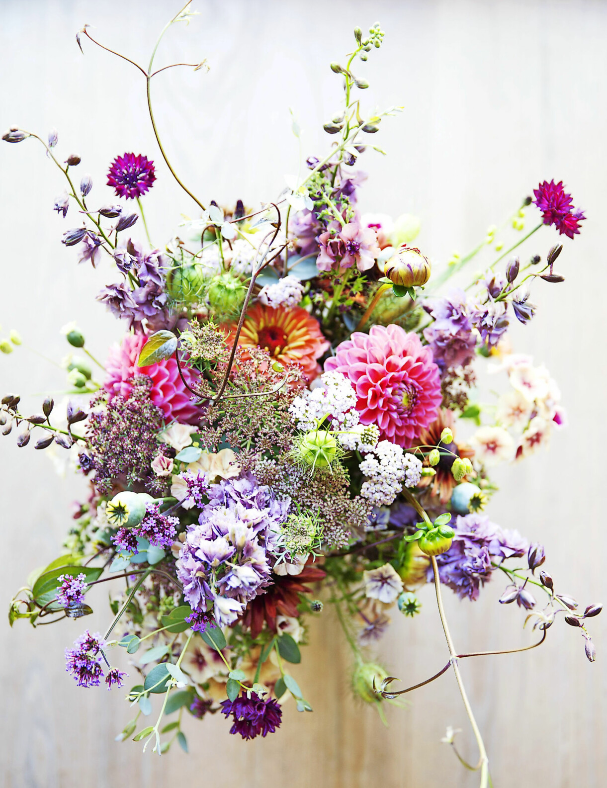 Sommarbukett med sommarflox, blåklint, jungfrun i det gröna, vildmorot, dahlia, vallmokapslar, ringblomma, kungsljus, sommarriddarsporre och röllika. Sommarbukett med bland annat dahlia, sommarflox, blåklint och vildmorot.