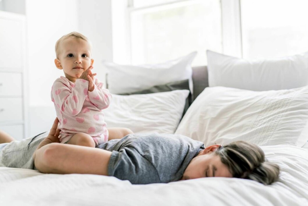 Att sova medan barnet sover är ett bra tips. Ibland blir det inte som man planerat. Foto: Shutterstock/TT Trött pappa med ett vaket barn på ryggen.