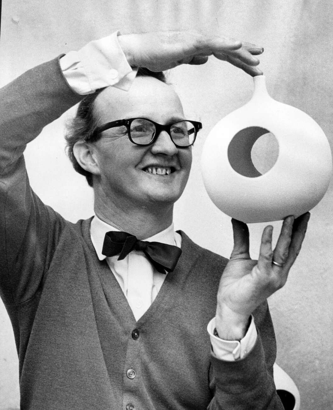 1960-tal. Stig Lindberg med en modern matkopp för fåglar. Stig Lindberg med en modern matkopp för fåglar.
