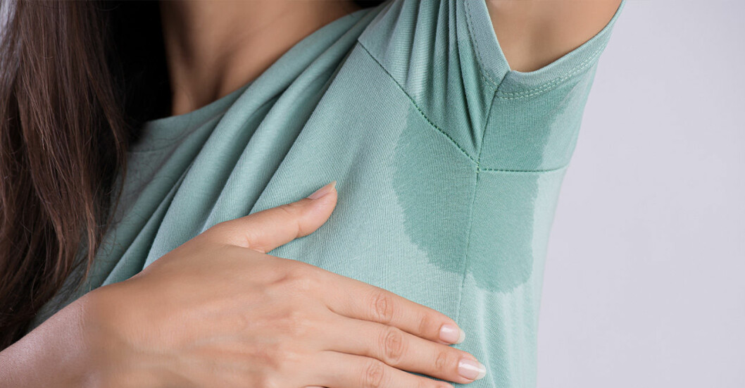 En kvinna med rejäla svettningar under armarna på grund av en deodorant som inte riktigt fungerar som den ska.