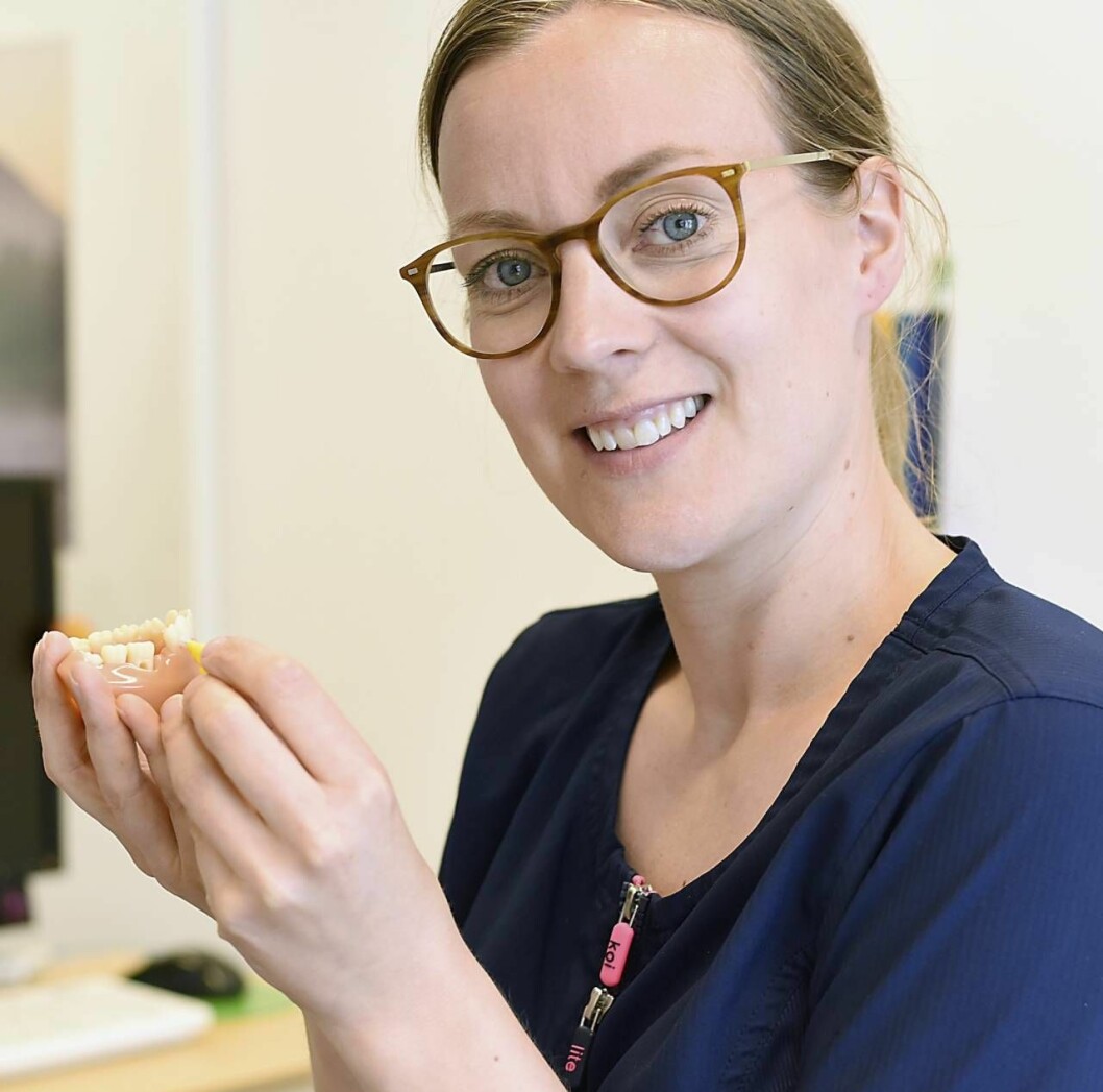 Tandhygienist Maria Lindvall med en tandmodell i handen. 