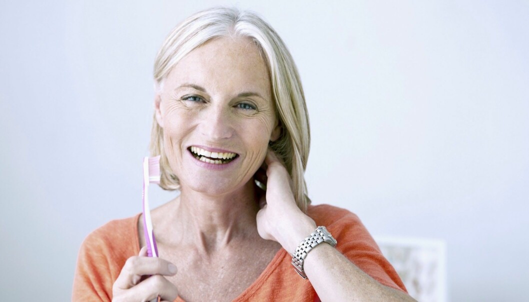 Glad kvinna håller en tandborste i handen