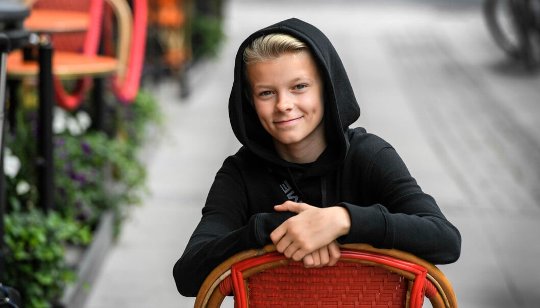Artisten Theoz sitter på en röd stol.