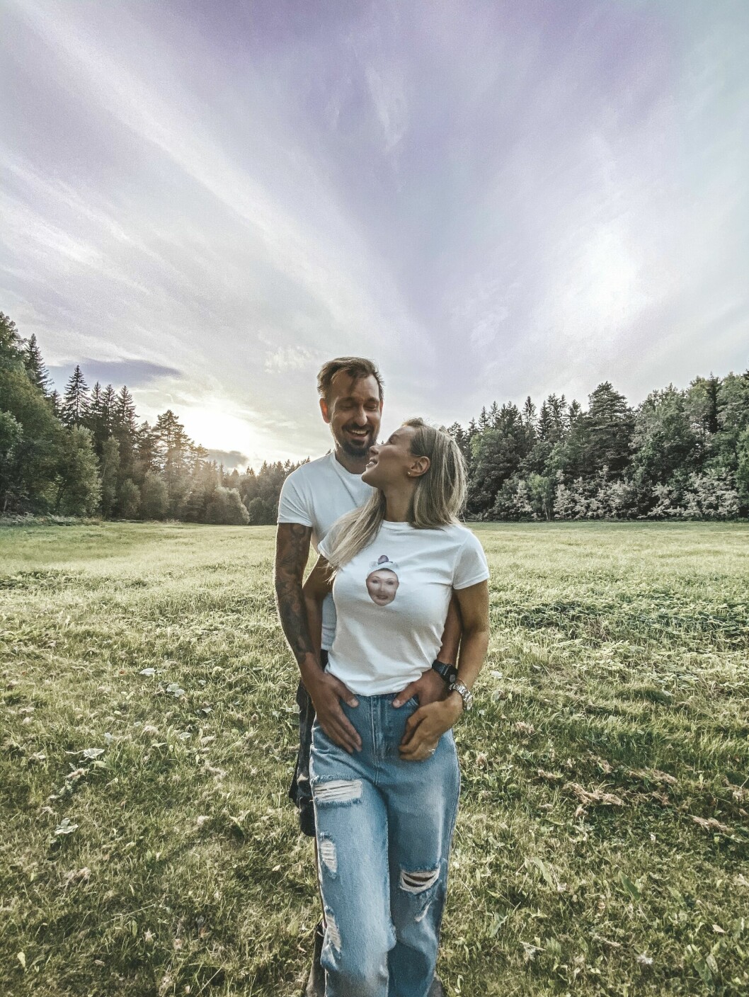 Therése Lindgren står på ett öppet fält mellan träden, där pojkvännen Anders Vesterlund håller om henne bakifrån. Hon vänder ansiktet bakåt mot honom och de tittar kärleksfullt på varandra.
