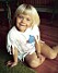 Therése Lindgren som liten flicka, sittande på golvet iförd en t-shirt med hemma-målat motiv och klippta fransar.