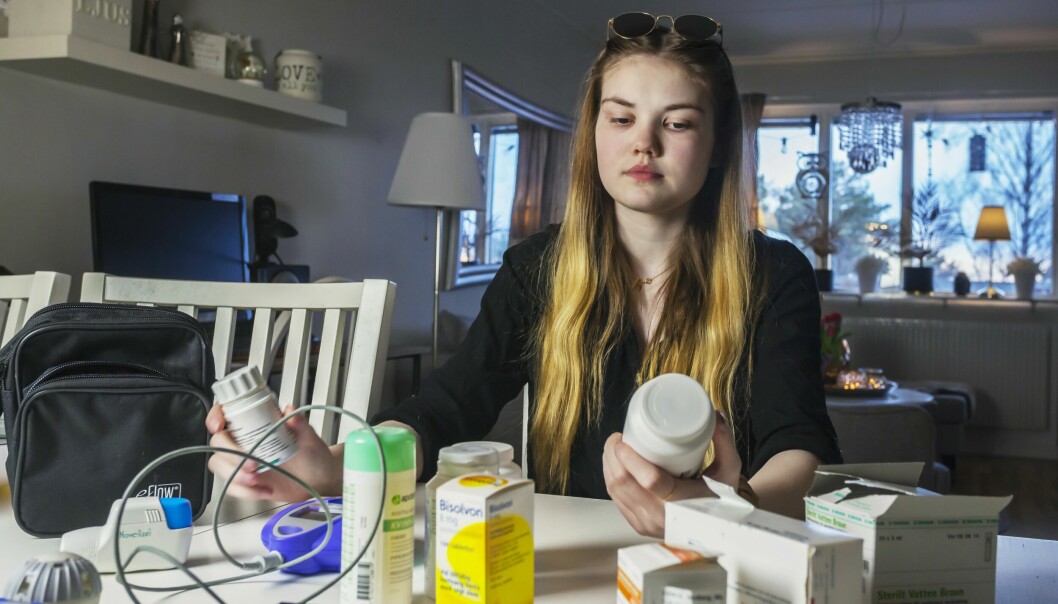 Tilde har cystisk fibros och sitter vid ett bord och har många pillerburkar, medicinaskar och annat hon behöver för att klara vardagen.