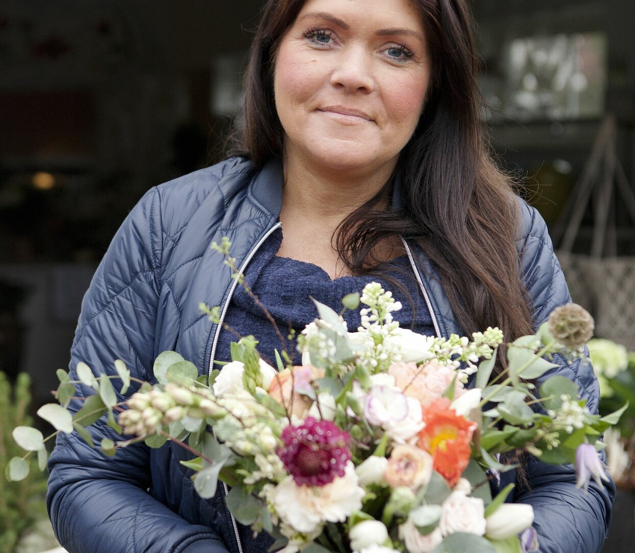 Tottie Larsson är blomsterkreatör från Höllviken i Skåne. Hennes vackra vårbukett bygger på vita tulpaner men innehåller även ranunkler, rosor, persikofärgad nejlika, praktvädd, klematis, bukettanemon, samt kvistar av syren, spirea och eukalyptus. Foto: Therése A. Svensson Tottie Larsson med vår fina vårbukett.