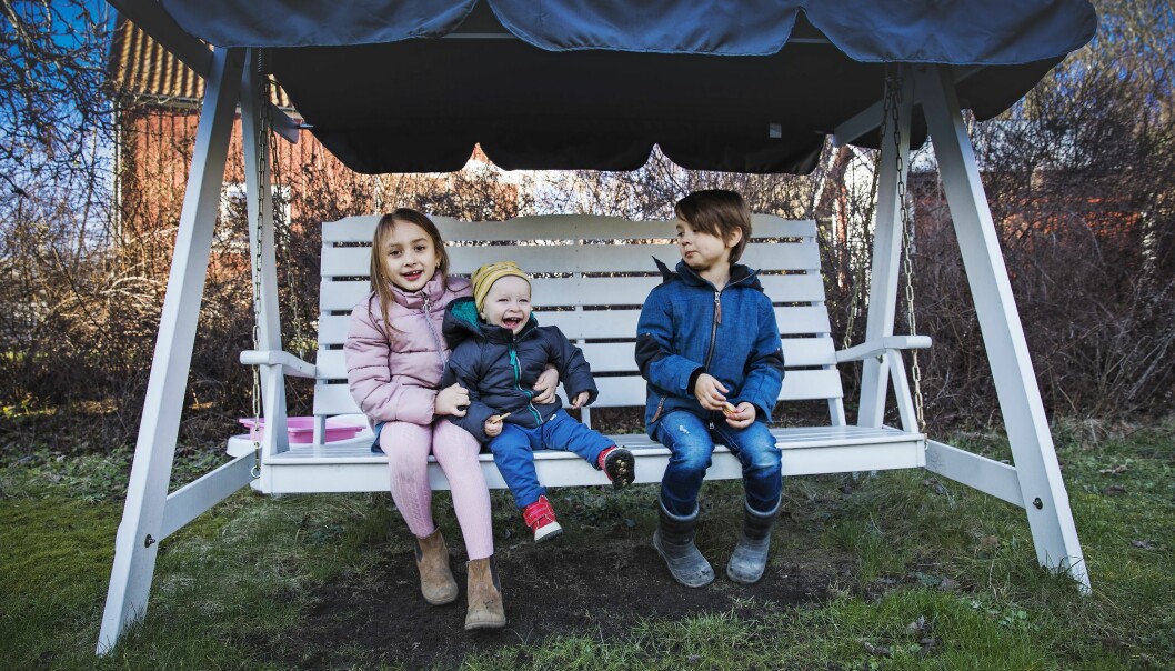 I dag är Tim en glad kille, älskad av syskonen Lova och Hugo. Foto: Veronica Kindblad Tre syskon i hammocken, storasyster håller om den skrattande Tim.