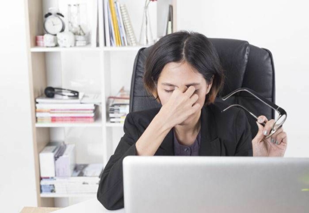 Foto: Shutterstock/IBL Trött kvinna sitter vid datorn