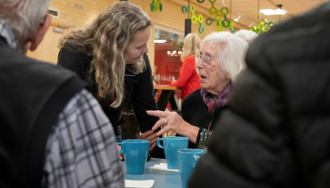 Två kvinnor sitter och pratar på ett MS-café.