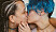 Två tonårstjejer kysser varandra.