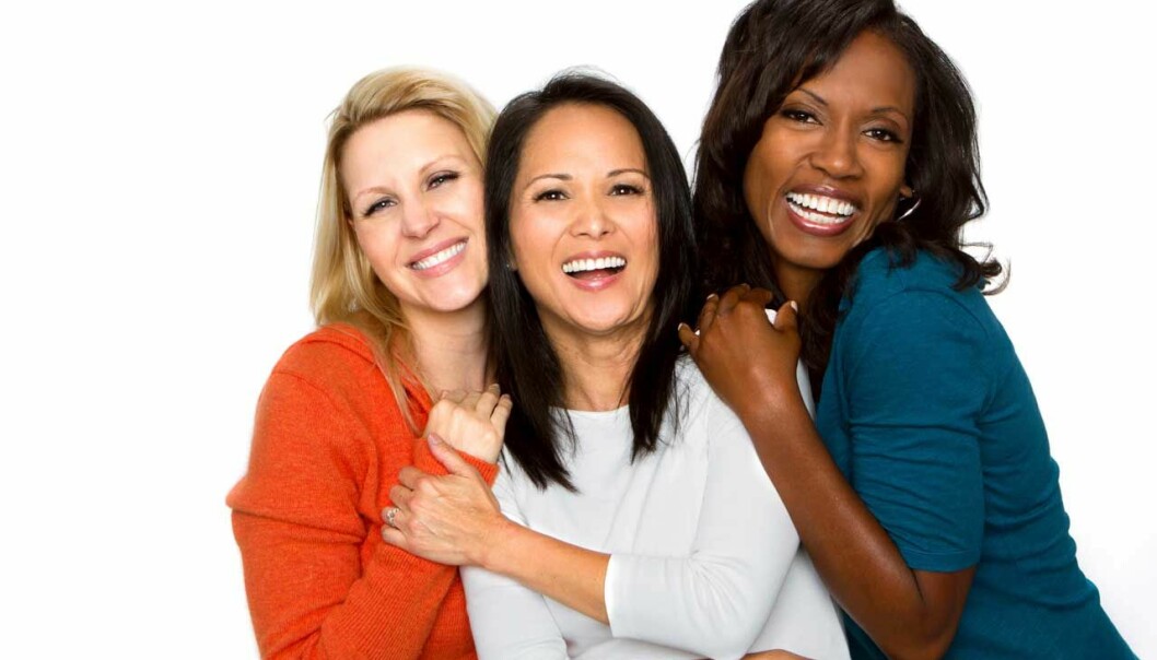 Tre kvinnor ler och har trevligt ihop.
