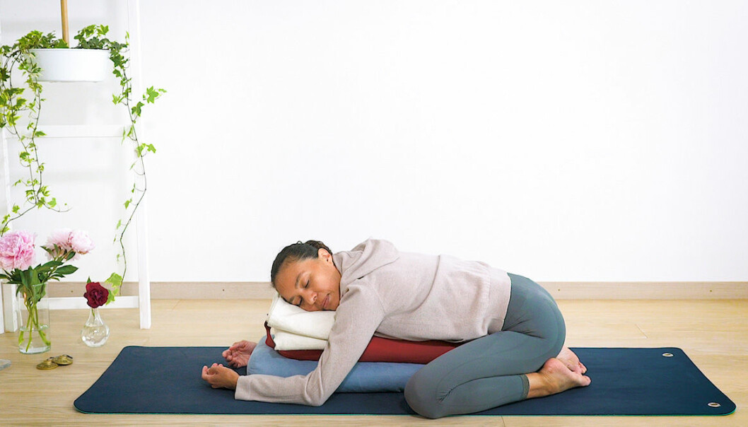 Yogainstruktör visar yogaövningar som hjälper dig med mensvärk och pms